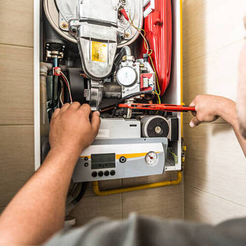 Repairman servicing or repairing furnace